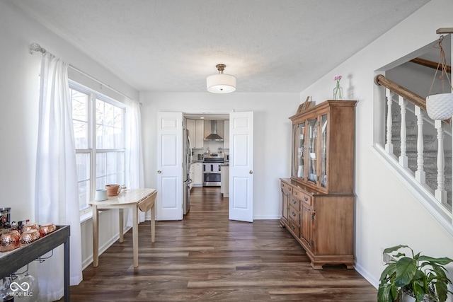 hallway featuring baseboards, dark wood-style floors, and stairs