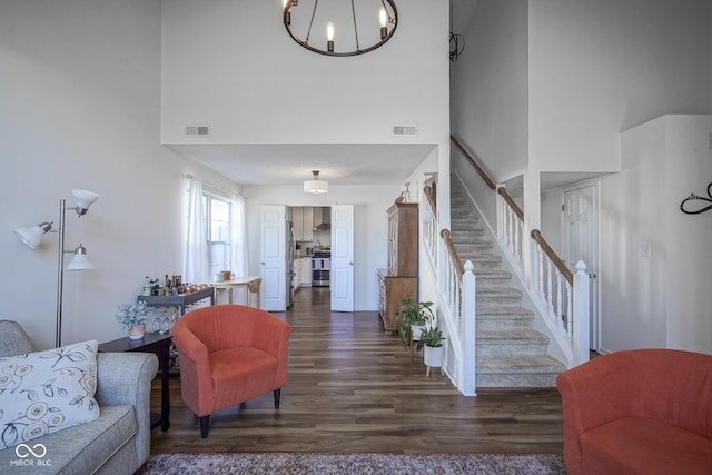 living area featuring visible vents, a high ceiling, dark wood-style flooring, and stairway