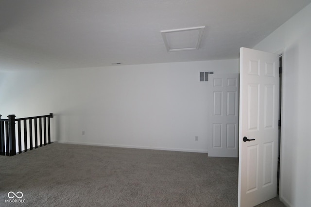 empty room with attic access, visible vents, and carpet flooring