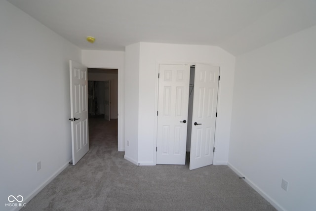 unfurnished bedroom with carpet floors, a closet, and baseboards