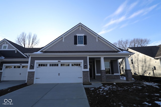 view of front of property featuring a garage, stone siding, a porch, and concrete driveway