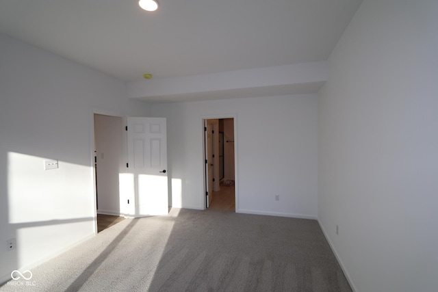 spare room featuring carpet floors and baseboards