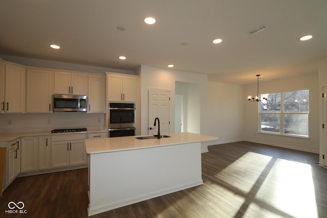 kitchen with a center island with sink, stainless steel appliances, recessed lighting, white cabinets, and a sink