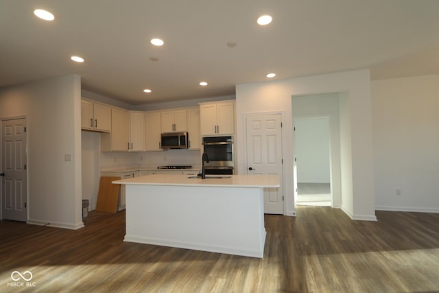 kitchen featuring light countertops, appliances with stainless steel finishes, dark wood-type flooring, and recessed lighting