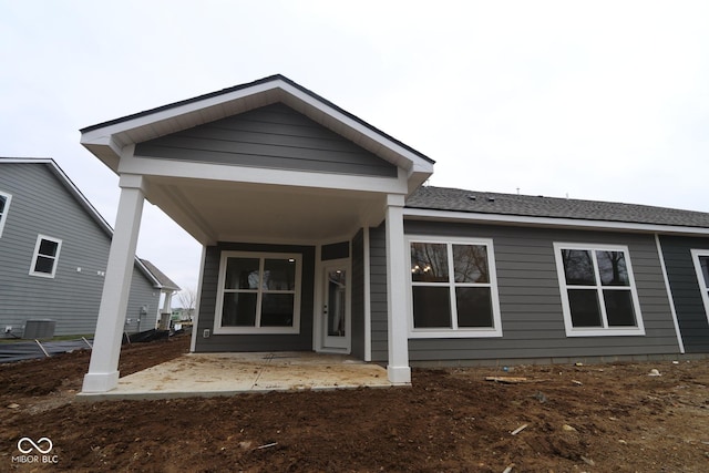 back of house featuring a shingled roof and a patio