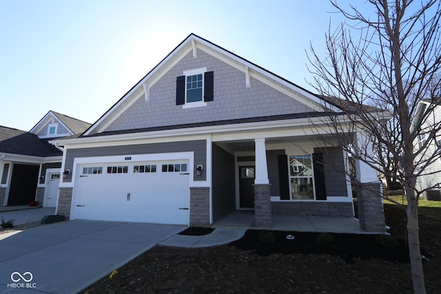 view of front facade with stone siding, a garage, covered porch, and driveway