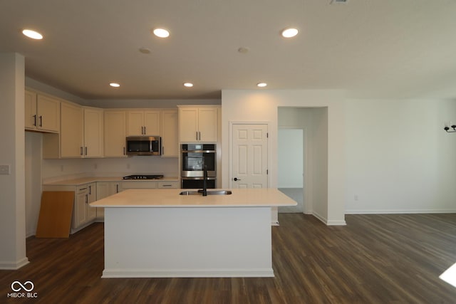 kitchen featuring recessed lighting, stainless steel appliances, a kitchen island with sink, and light countertops