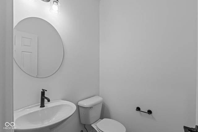 half bathroom featuring toilet and a sink
