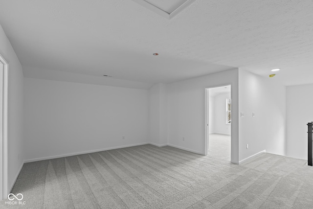 carpeted spare room with baseboards and a textured ceiling