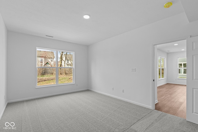 unfurnished room featuring baseboards, carpet floors, and a healthy amount of sunlight