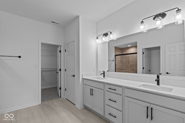full bathroom featuring a shower stall, double vanity, visible vents, and a sink