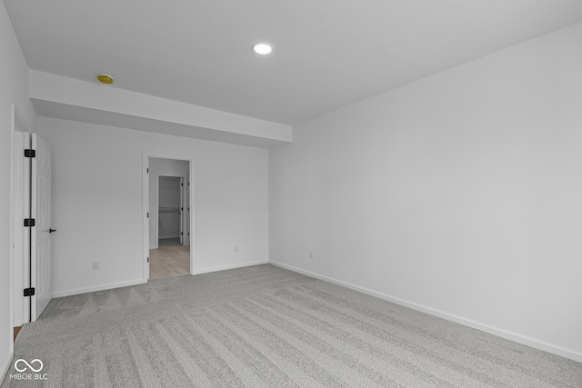 carpeted empty room featuring baseboards and recessed lighting