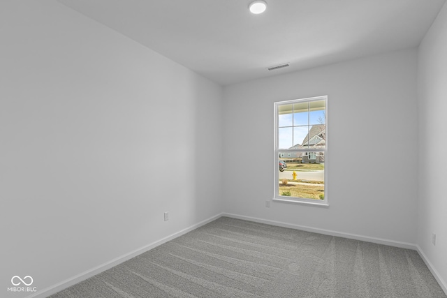 spare room with baseboards, carpet floors, and visible vents