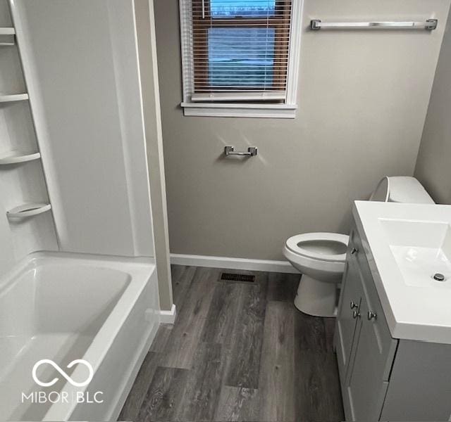 bathroom with vanity, wood finished floors, toilet, and baseboards