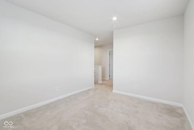 unfurnished room featuring recessed lighting, light carpet, and baseboards