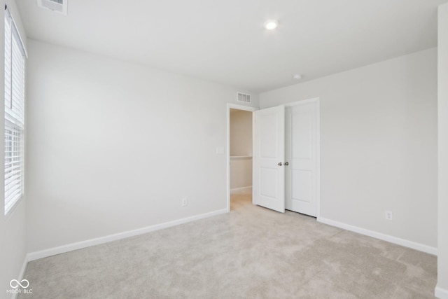 unfurnished bedroom with carpet, visible vents, and baseboards