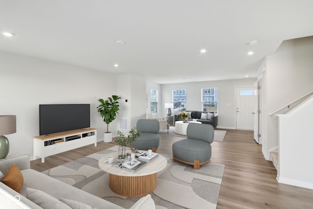 living room featuring recessed lighting, baseboards, stairway, and light wood finished floors