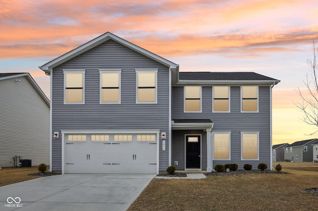 traditional-style house featuring driveway, an attached garage, and a front yard