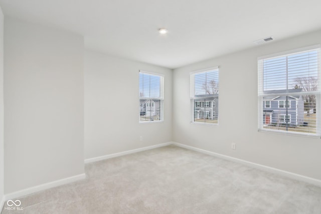 carpeted empty room with baseboards and visible vents