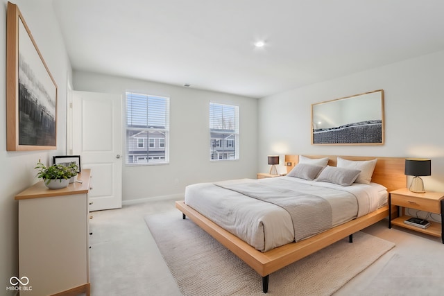 bedroom featuring light carpet and baseboards