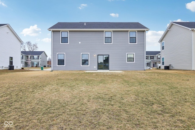 back of house with central AC and a lawn