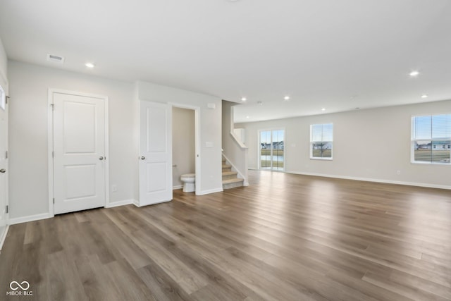 interior space with recessed lighting, visible vents, stairway, wood finished floors, and baseboards