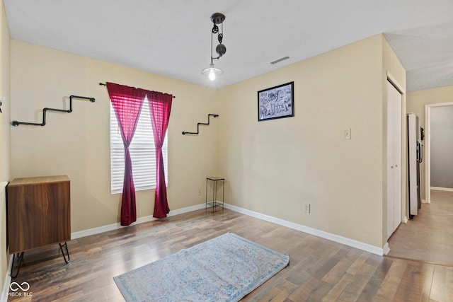 interior space featuring visible vents, baseboards, and wood finished floors