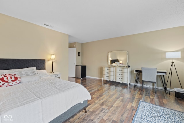 bedroom with wood finished floors, visible vents, and baseboards