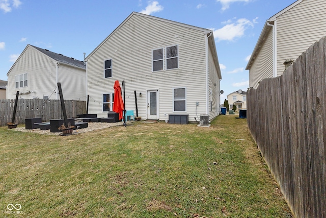 rear view of house with a yard, central AC unit, and a fenced backyard