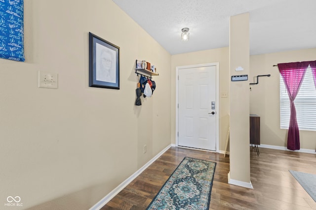 entryway featuring a textured ceiling, baseboards, and wood finished floors