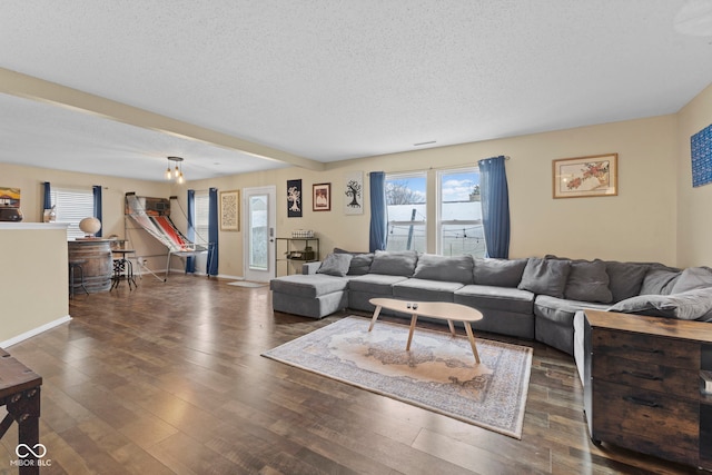 living area with baseboards, a textured ceiling, and hardwood / wood-style floors