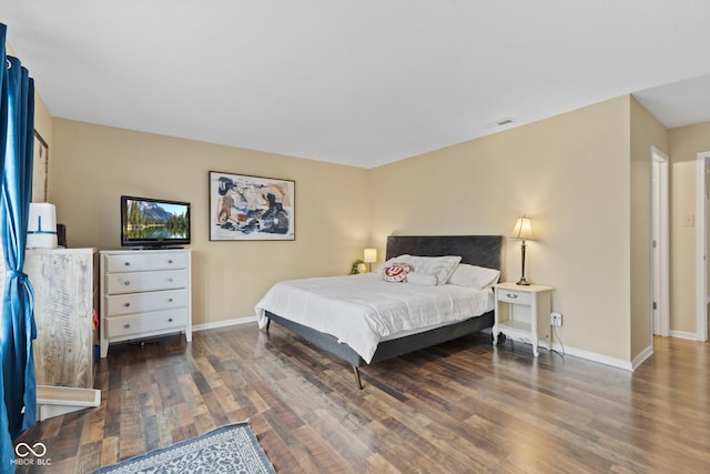 bedroom featuring visible vents, baseboards, and wood finished floors