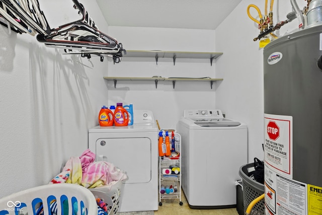 washroom with gas water heater, washer and clothes dryer, and laundry area