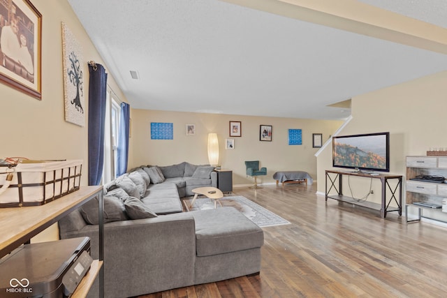 living room with visible vents, baseboards, and wood finished floors