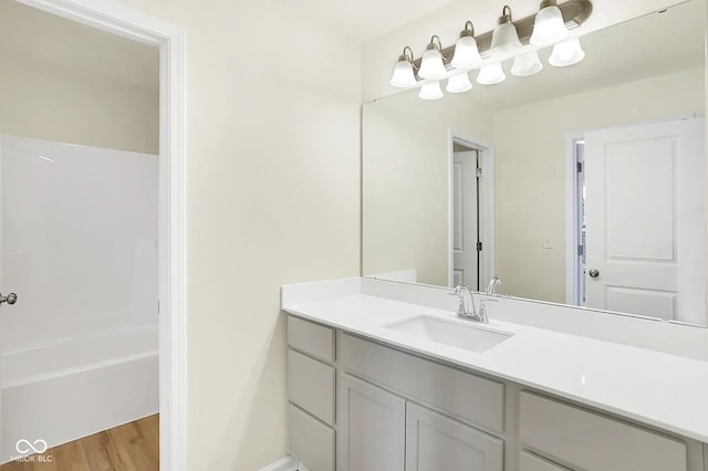 full bathroom featuring tub / shower combination, wood finished floors, and vanity