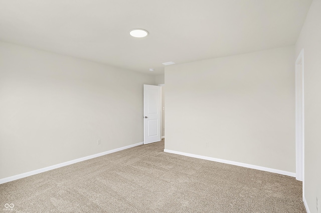 empty room featuring baseboards and carpet flooring