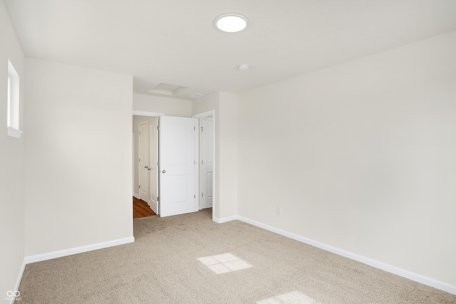 unfurnished bedroom with carpet floors, attic access, and baseboards