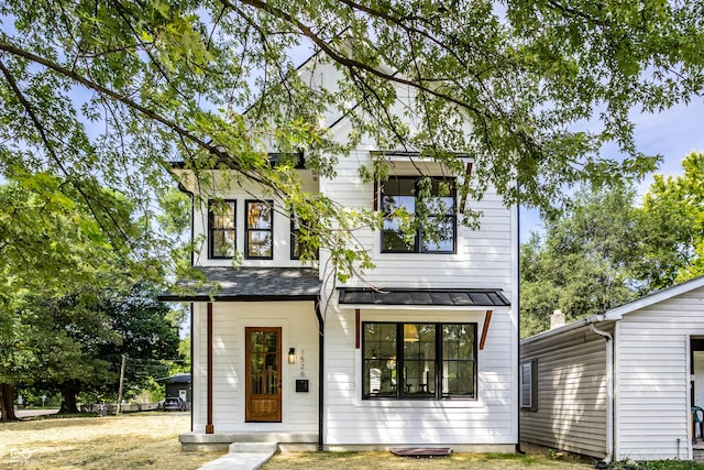 view of front of property with metal roof, a standing seam roof, and roof with shingles