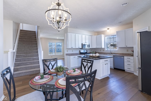 kitchen featuring appliances with stainless steel finishes, a wealth of natural light, a sink, and dark wood-style floors