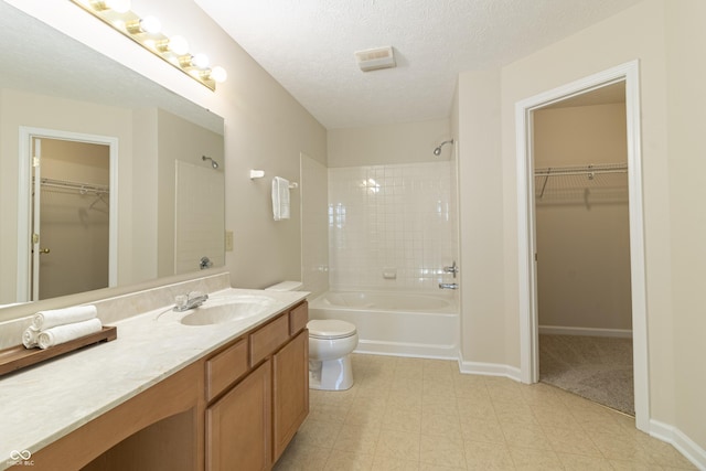 bathroom with a textured ceiling, toilet, vanity, baseboards, and  shower combination