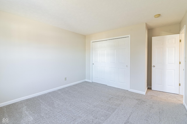 unfurnished bedroom with carpet, baseboards, and a closet