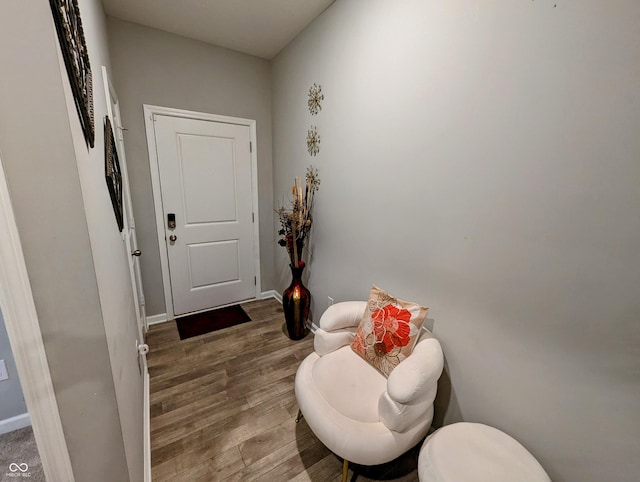 doorway with wood finished floors and baseboards