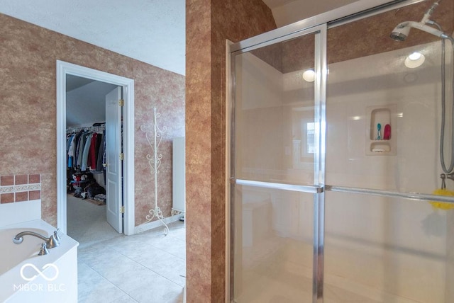 full bath with a garden tub, a shower stall, a walk in closet, and tile patterned floors