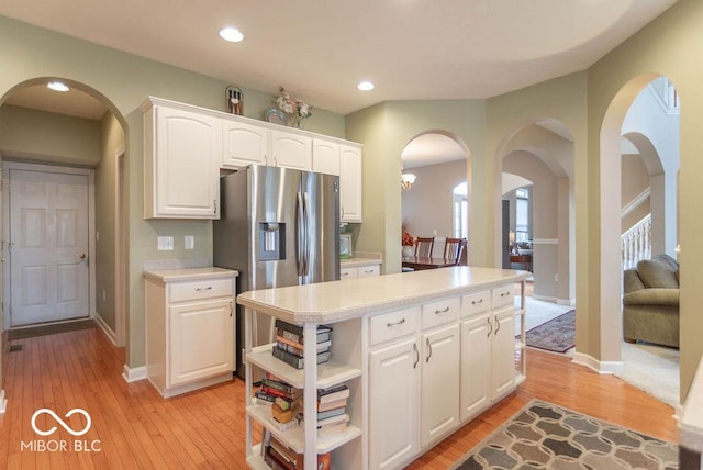 kitchen with light countertops, white cabinets, light wood finished floors, and open shelves