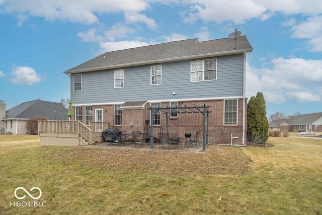 back of property featuring brick siding, a yard, and a patio