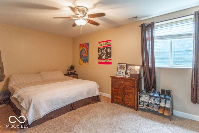 carpeted bedroom with a ceiling fan, visible vents, and baseboards