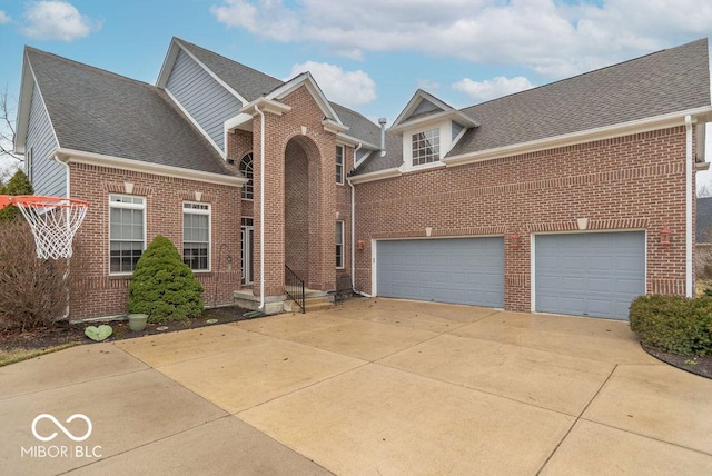 traditional-style house with an attached garage, concrete driveway, brick siding, and a shingled roof