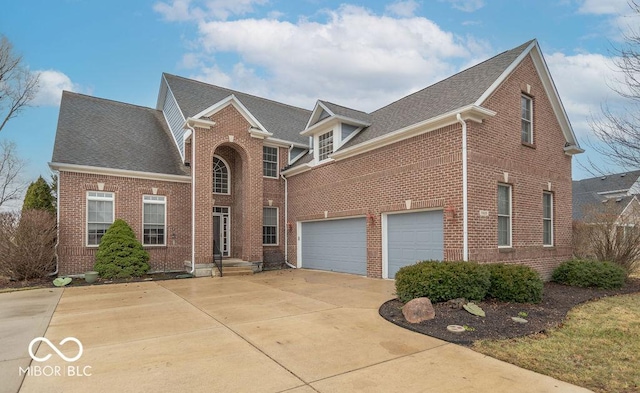 traditional home featuring driveway, a shingled roof, and brick siding