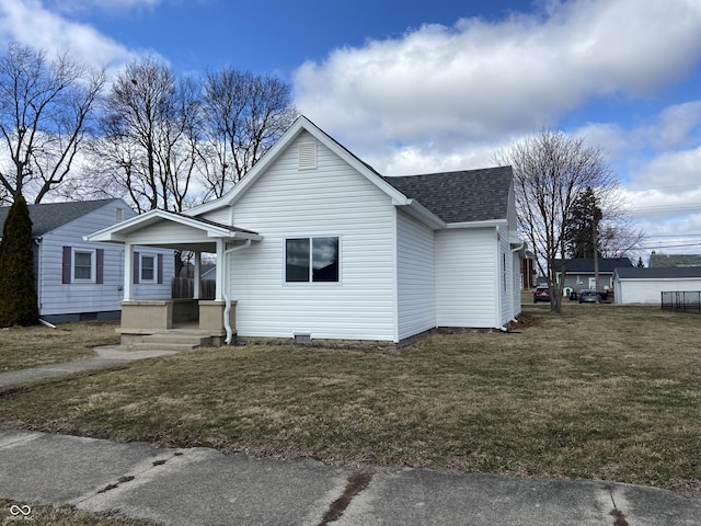 bungalow featuring a shingled roof and a front lawn