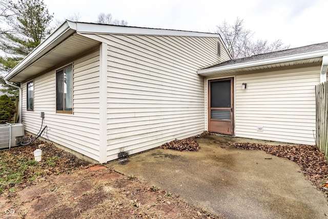 view of side of property with a patio area and central air condition unit